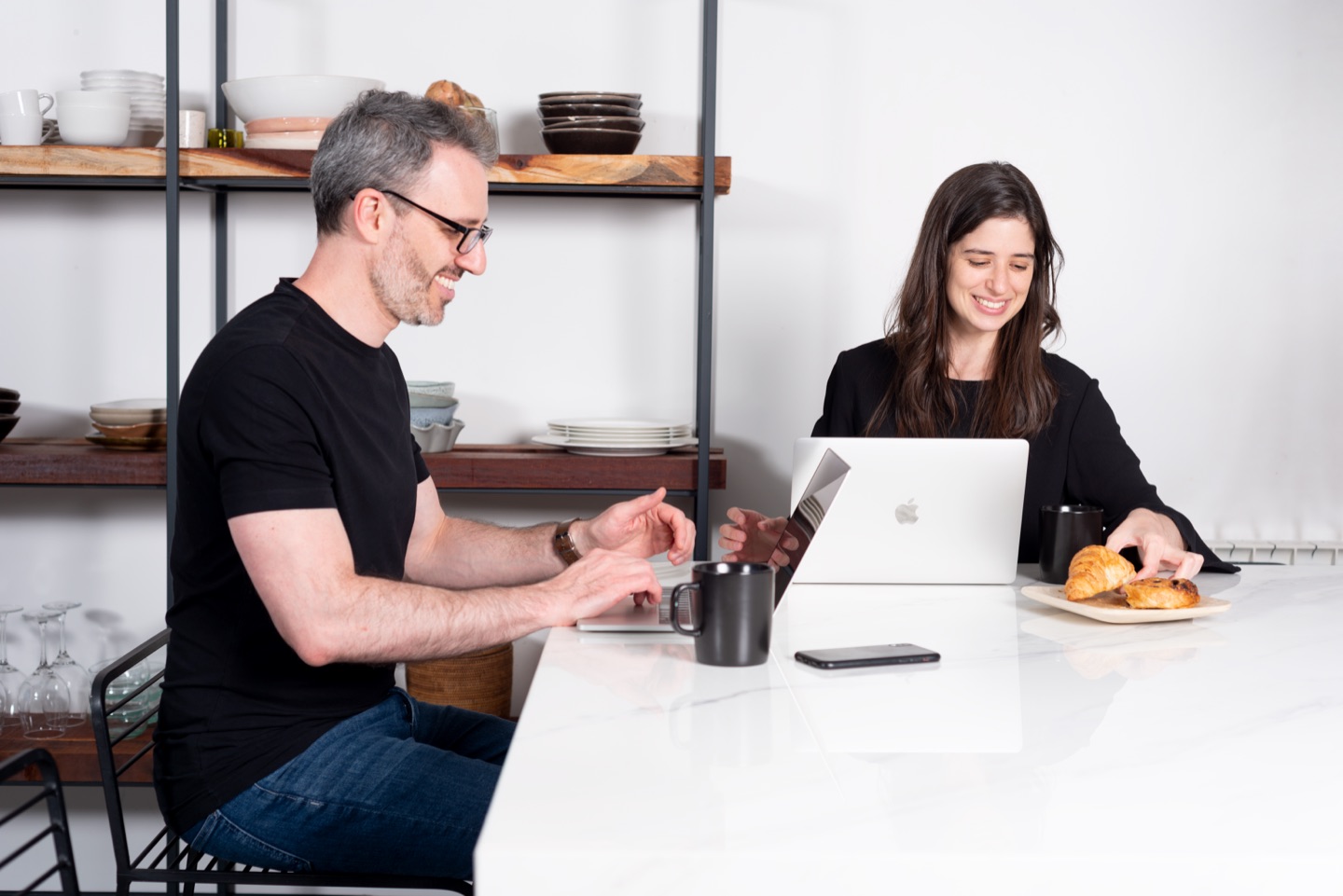 Mai and Javier at work with coffee and croissants